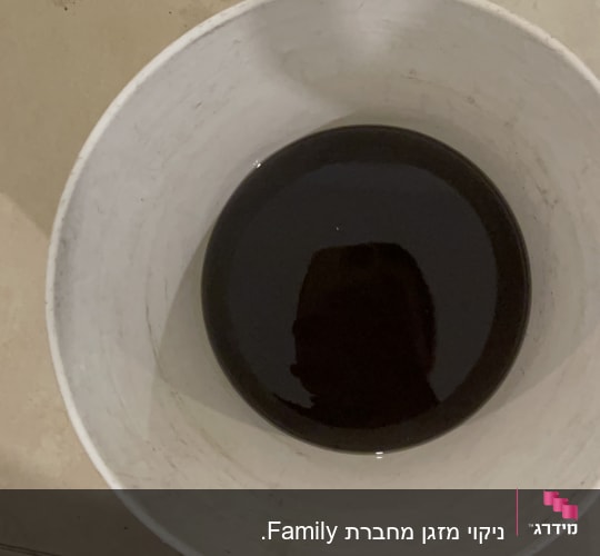 דלי עם נוזל כהה על רצפה